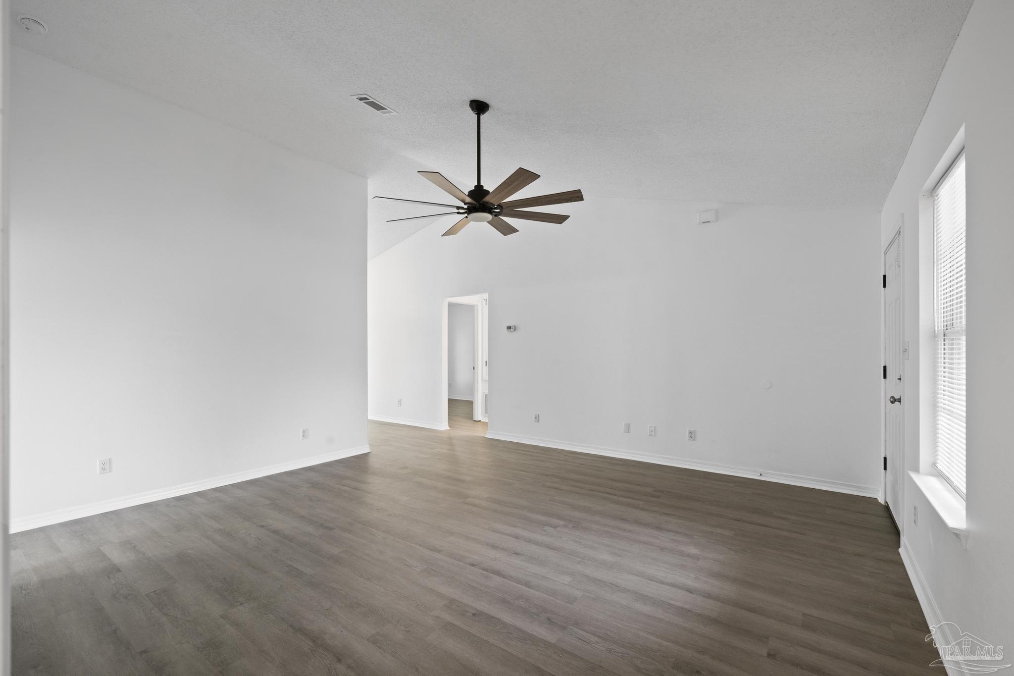 5564 Paddle Wheel Drive Milton, FL 32583 - Photo 15 of 41 a view of a room with wooden floor and a ceiling fan