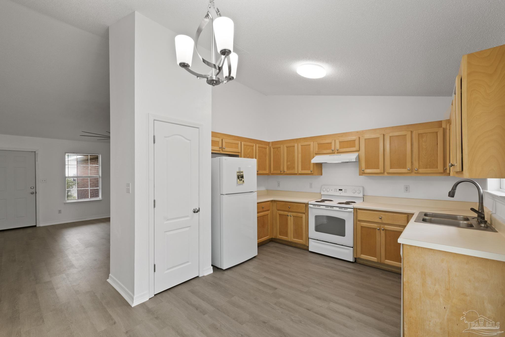 5564 Paddle Wheel Drive Milton, FL 32583 - Photo 6 of 41 a kitchen with stainless steel appliances granite countertop a sink cabinets a refrigerator and wooden floor