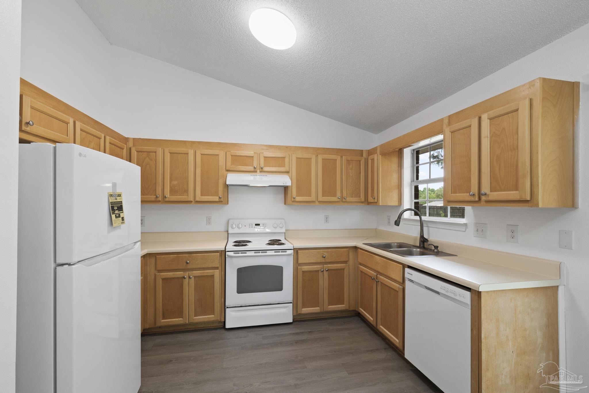 5564 Paddle Wheel Drive Milton, FL 32583 - Photo 7 of 41 a kitchen with stainless steel appliances granite countertop a sink a stove a refrigerator with grey cabinets