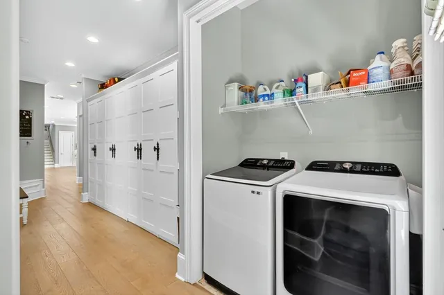 a living room with stainless steel appliances furniture and a kitchen view