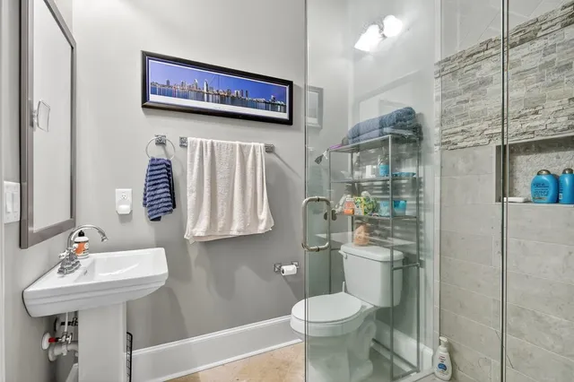 a bathroom with a sink toilet vanity and shower
