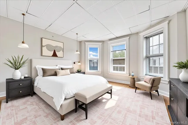 a spacious bedroom with a bed a couch and large window