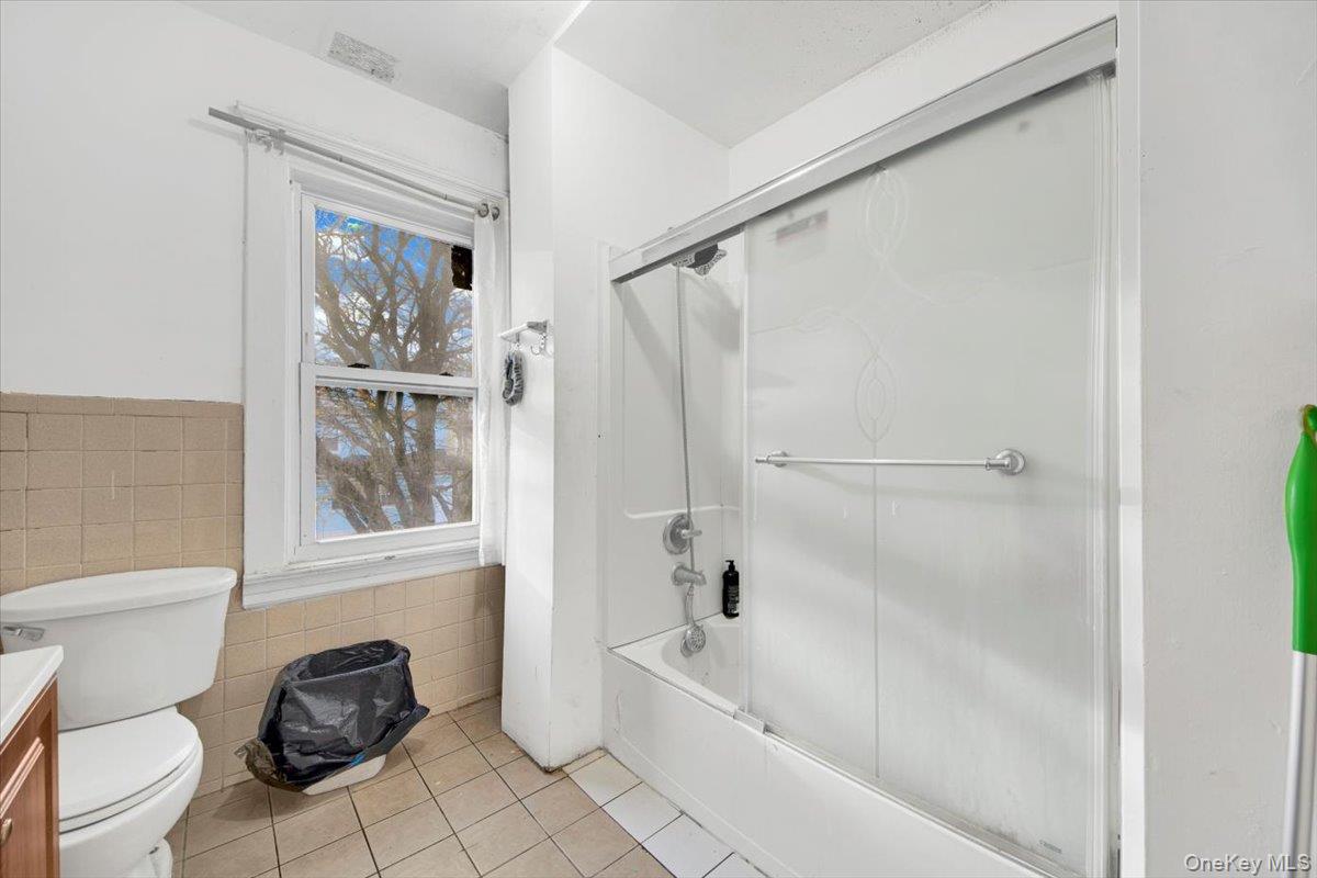 59 Jackson Street New Rochelle, NY 10801 - Photo 15 of 15 a bathroom with a granite countertop bathtub shower sink vanity and toilet
