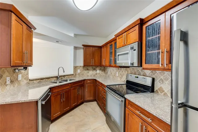a kitchen with stainless steel appliances granite countertop a sink and a stove