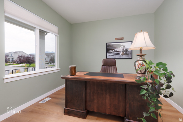 1654 South 730 West Provo, UT 84601 - Photo 4 of 33 Bright room featuring light green walls, a large window with roller shades, white trim, and wood-finish flooring