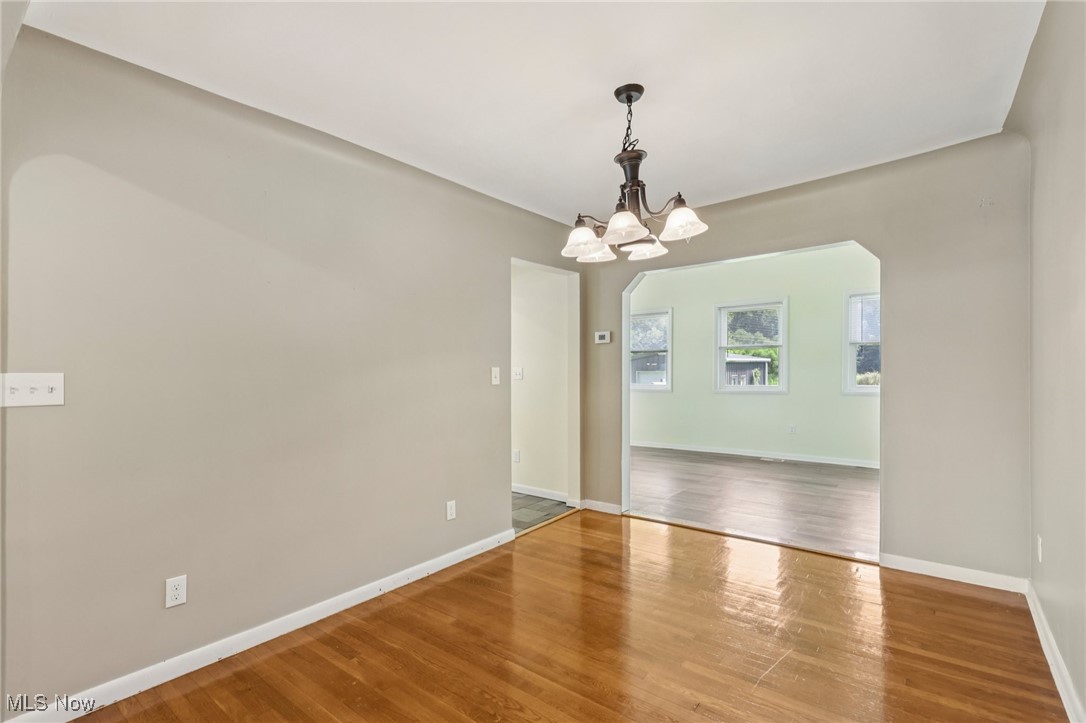 5097 Chillicothe Road Chagrin Falls, OH 44022 - Photo 20 of 45 Dining room with wood finished floors, a chandelier, and arched walkways