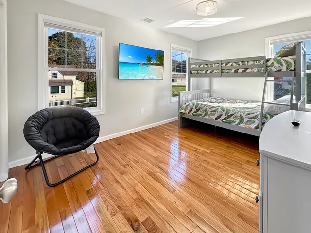 a view of a hallway with furniture and wooden floor