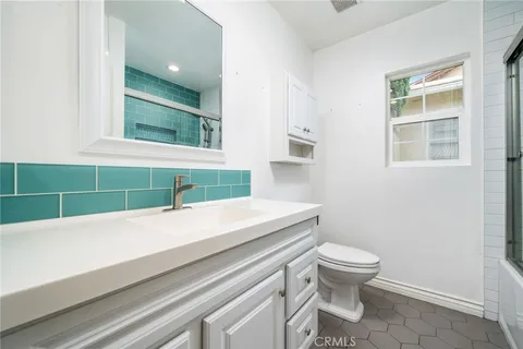 a bathroom with a sink a toilet and a window