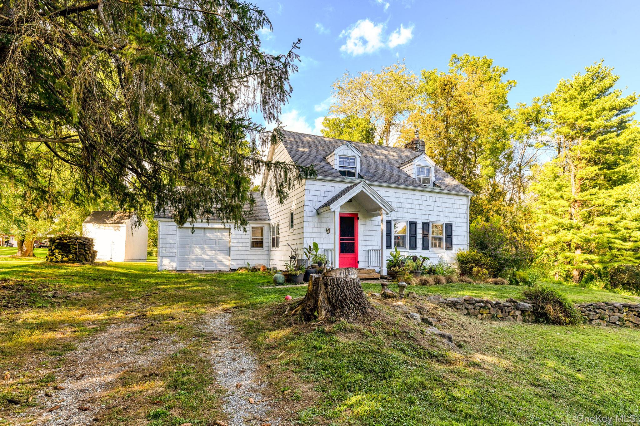 a view of a house with a big yard and large trees