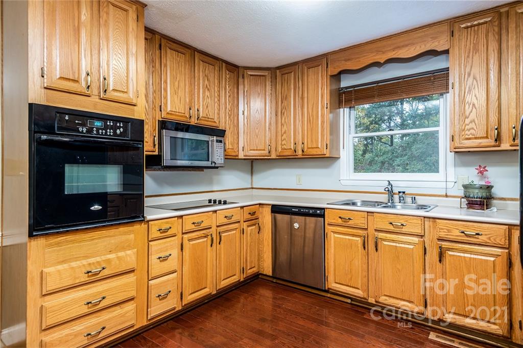804 Hillside Street Southwest Valdese, NC 28690 - Photo 16 of 25 a kitchen with granite countertop wooden cabinets stainless steel appliances a sink and a window