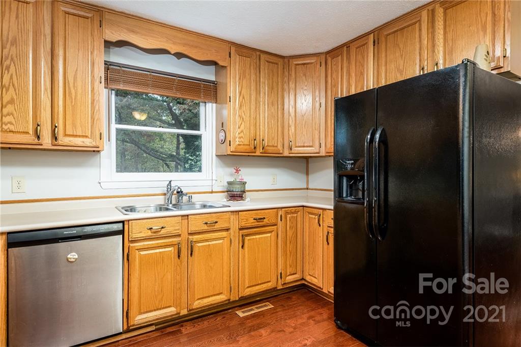 804 Hillside Street Southwest Valdese, NC 28690 - Photo 17 of 25 a kitchen with stainless steel appliances granite countertop a refrigerator a sink and dishwasher with a large window
