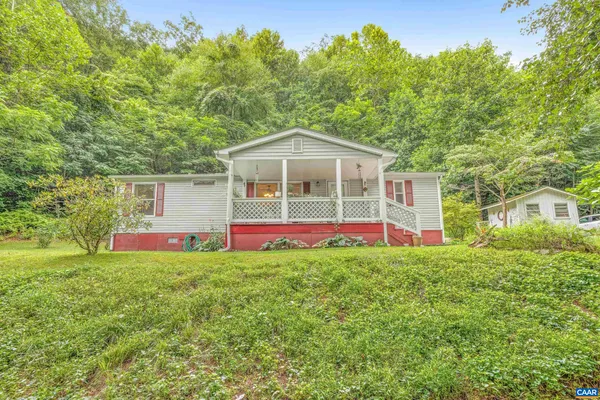 a front view of a house with a yard and trees