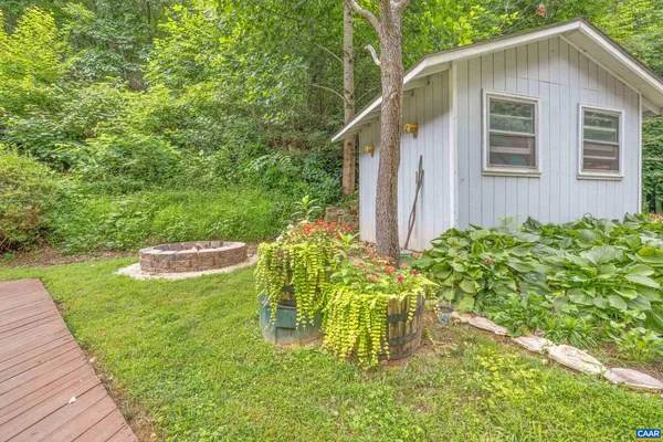 a view of a backyard with potted plants and large tree