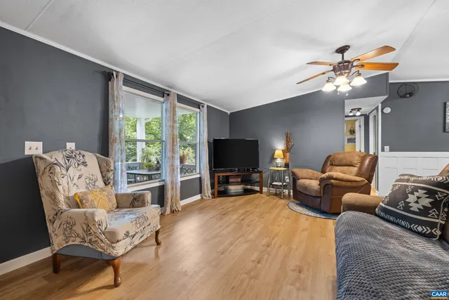 a living room with furniture a flat screen tv and a large window