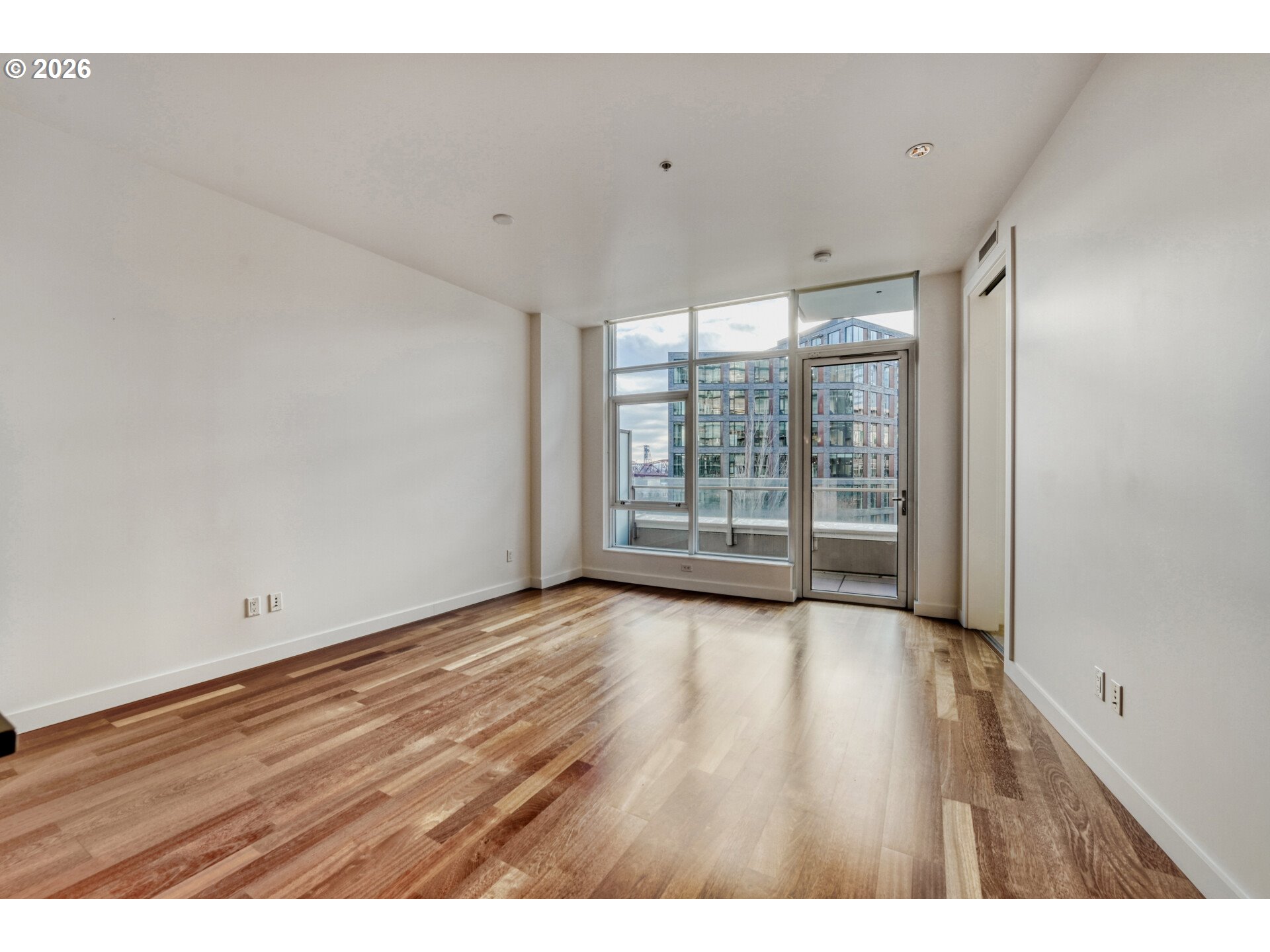 949 Northwest Overton Street, Unit 513 Portland, OR 97209 - Photo 11 of 35 a view of an empty room with wooden floor and a window