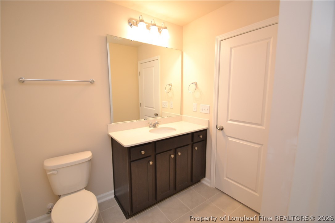 5703 Preveza Place Raleigh, NC 27603 - Photo 17 of 33 a bathroom with a toilet sink and mirror