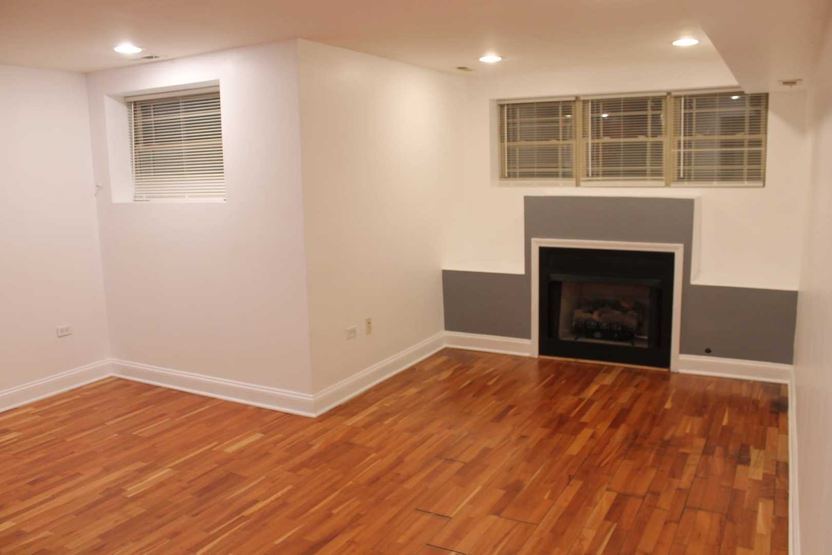 4944 North Spaulding Avenue, Unit G Chicago, IL 60625 - Photo 2 of 9 a view of an empty room with wooden floor and a window