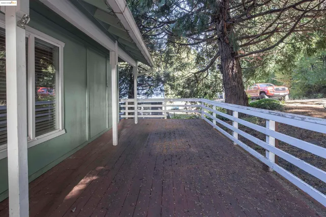 a view of a porch with wooden floor and fence