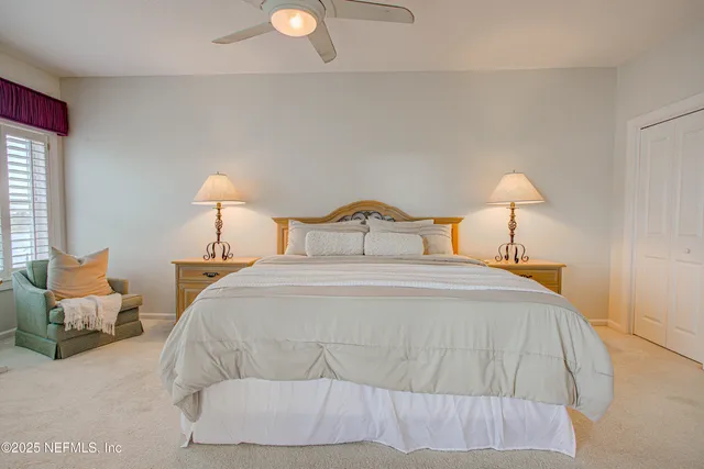 a bedroom with a bed and a lamp on dresser