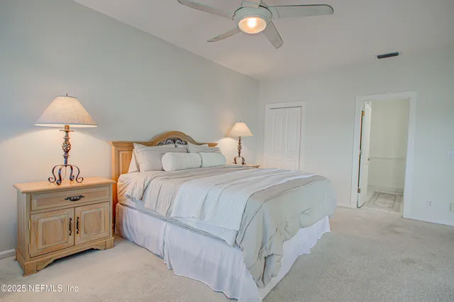 a bedroom with a large bed and a potted plant