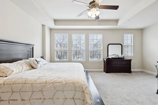 a spacious bedroom with a bed chandelier and a window