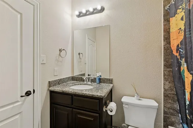 a room with stainless steel appliances kitchen island granite countertop furniture and a refrigerator
