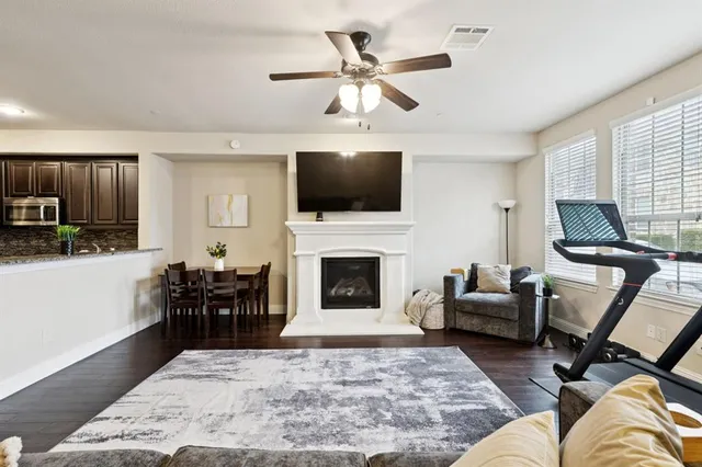 a kitchen with stainless steel appliances granite countertop wooden cabinets a sink dishwasher a stove and a microwave oven with wooden floor