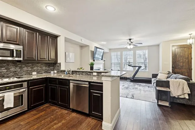 a kitchen with stainless steel appliances granite countertop a refrigerator and a sink