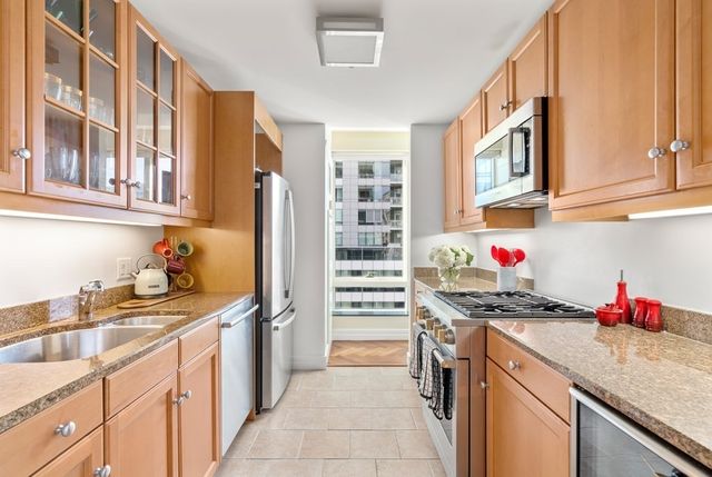 a kitchen with stainless steel appliances granite countertop a sink stove and cabinets
