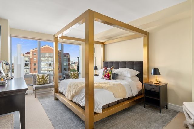 a bedroom with a bed lamp and a large window