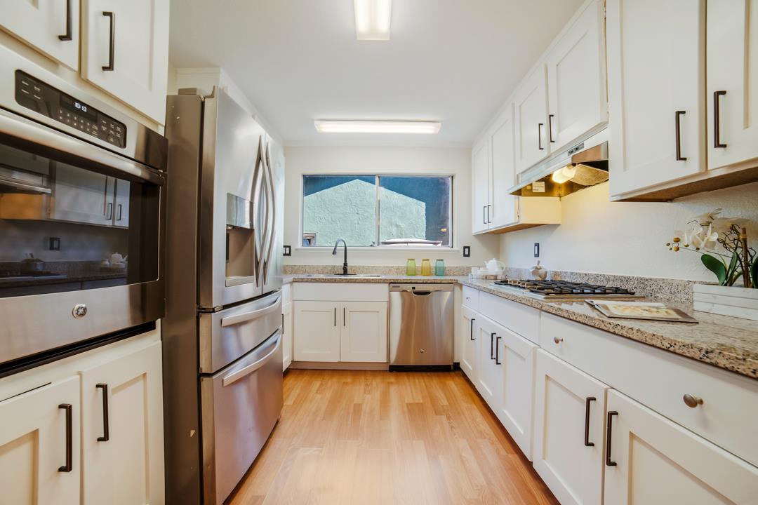 835 Fillippelli Drive Gilroy, CA 95020 - Photo 7 of 45 a kitchen with granite countertop white cabinets and white appliances