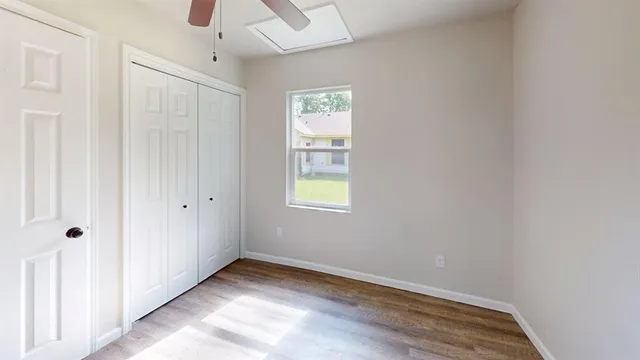 a view of an empty room with closet and a window