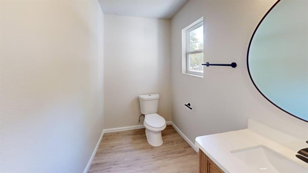 519 East Gandy Street Denison, TX 75021 - Photo 15 of 18 a bathroom with a sink toilet and a mirror
