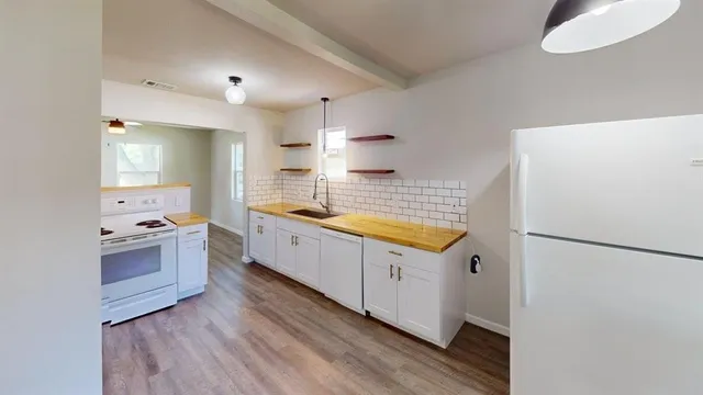 a kitchen with granite countertop a sink a counter space and stainless steel appliances
