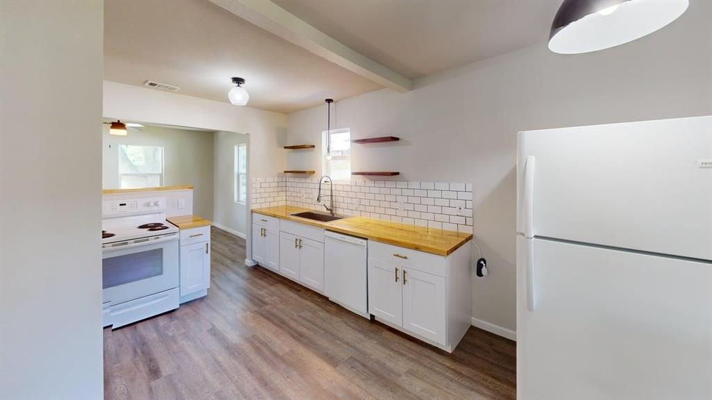 519 East Gandy Street Denison, TX 75021 - Photo 4 of 18 a kitchen with granite countertop a sink a counter space and stainless steel appliances
