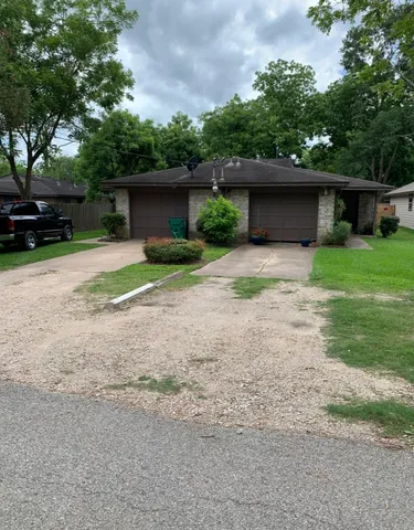 a view of a house with a yard and large tree