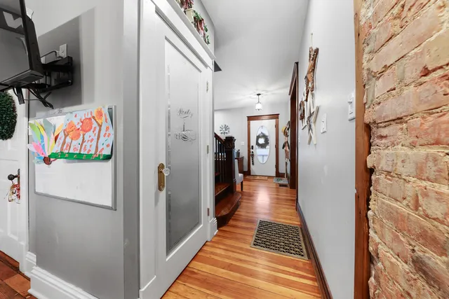 a hallway with wooden floor and cabinets