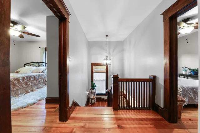 a view of a hallway with wooden floor and a mirror