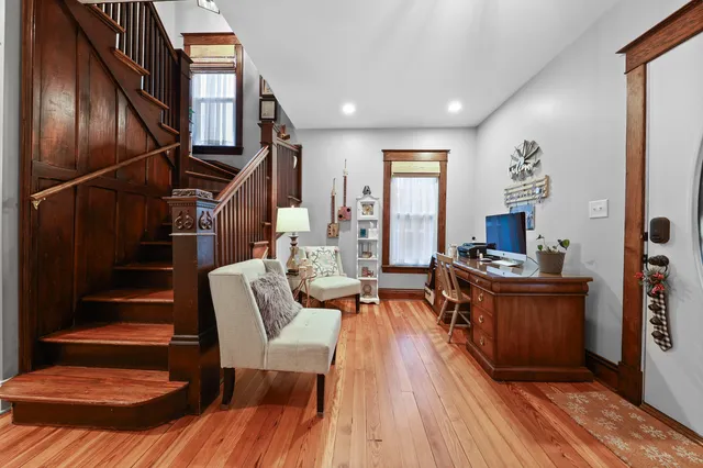 a living room with couches chairs and kitchen view with wooden floor