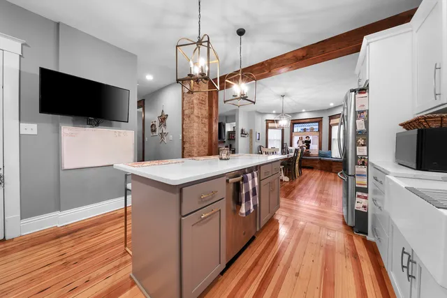 a large kitchen with stainless steel appliances kitchen island granite countertop a large counter top and wooden floors