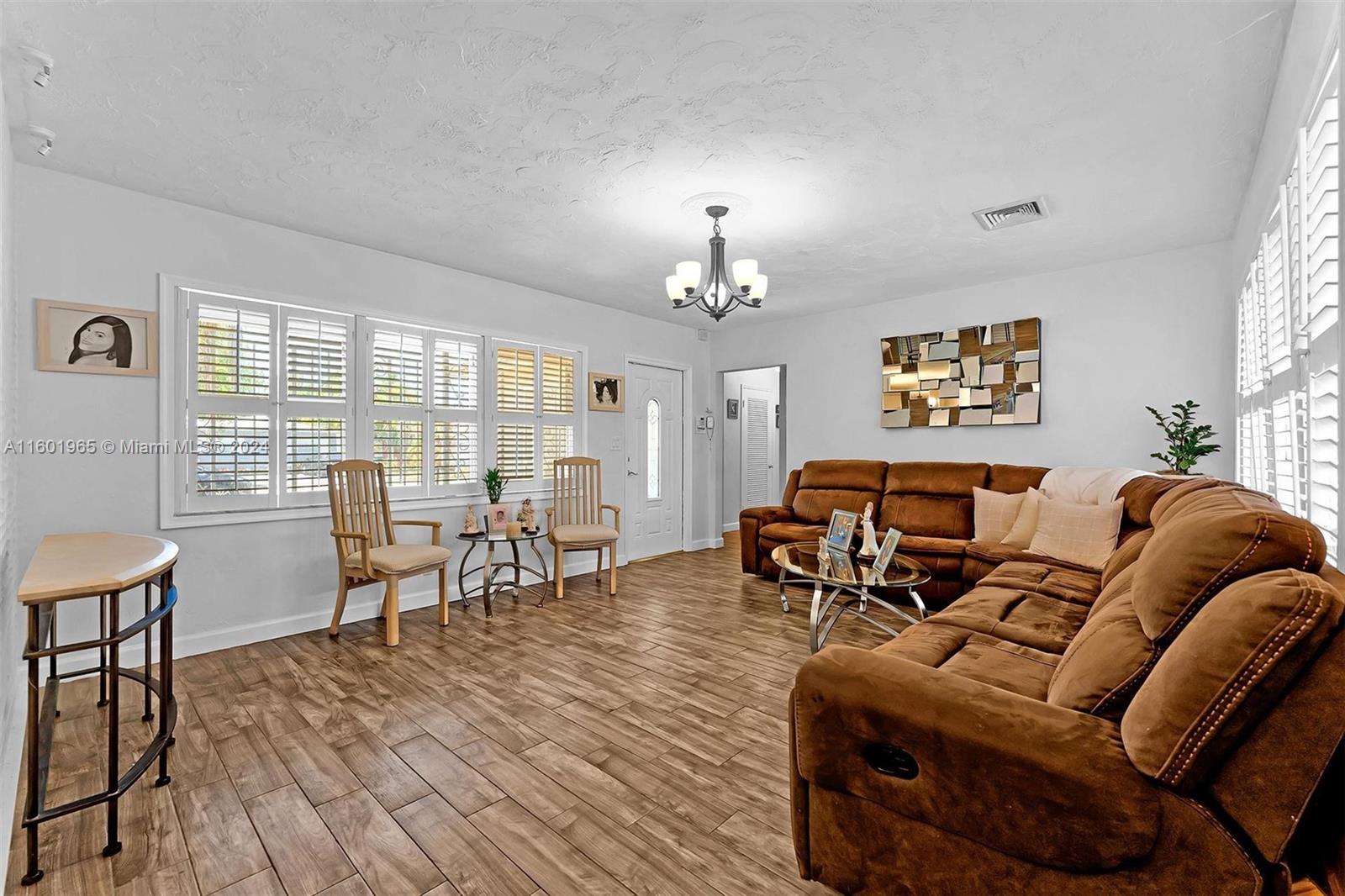23 Southwest 8th Street Hallandale Beach, FL 33009 - Photo 8 of 23 a living room with furniture and a dining table with wooden floor