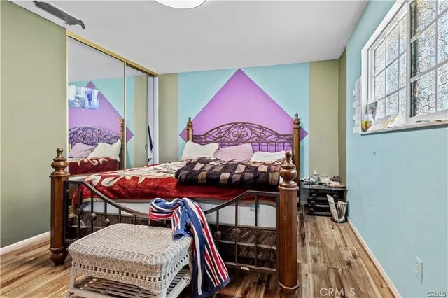 a view of a bedroom with furniture and wooden floor