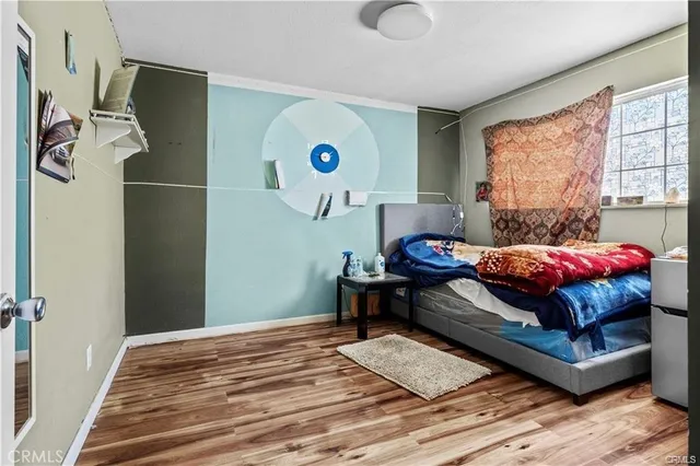 a bedroom with a bed and wooden floor