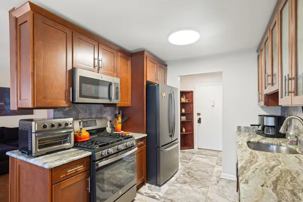 a kitchen with stainless steel appliances granite countertop a stove a refrigerator and a sink