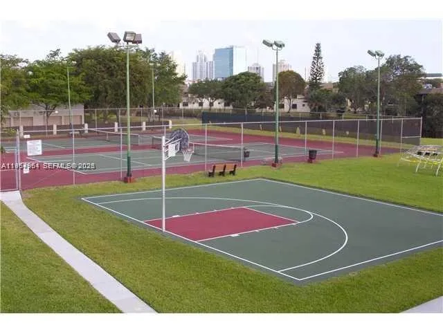 a view of a tennis ground with large trees