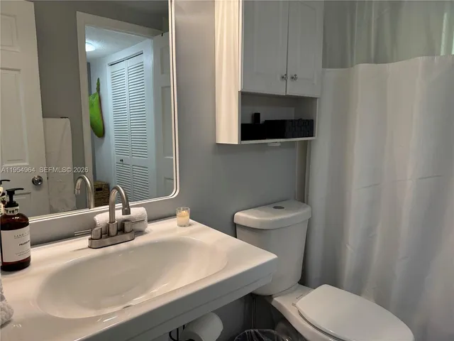 a bathroom with a toilet a sink and mirror