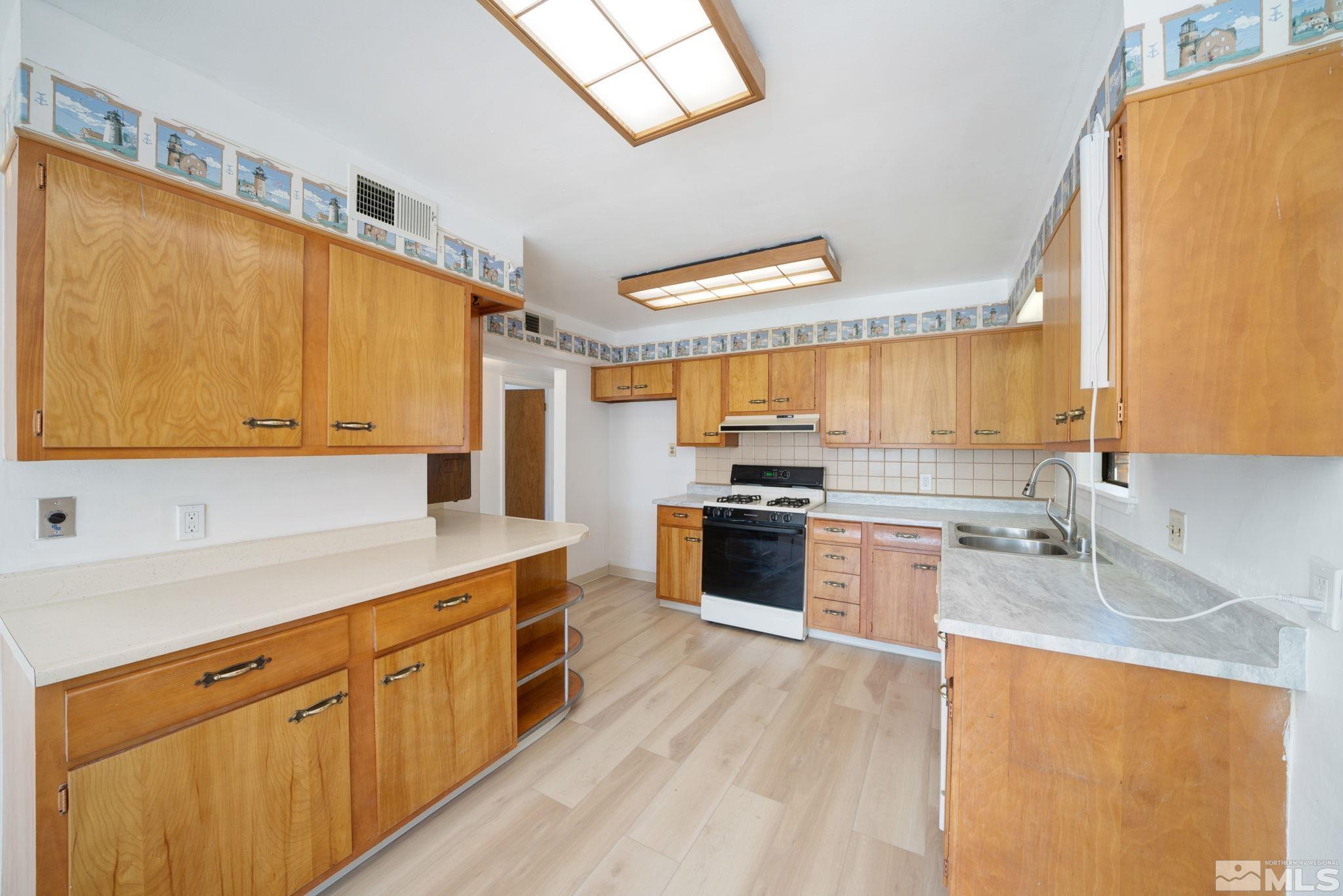 1535 Harvard Way Reno, NV 89502 - Photo 12 of 26 a kitchen with stainless steel appliances a sink cabinets and wooden floor