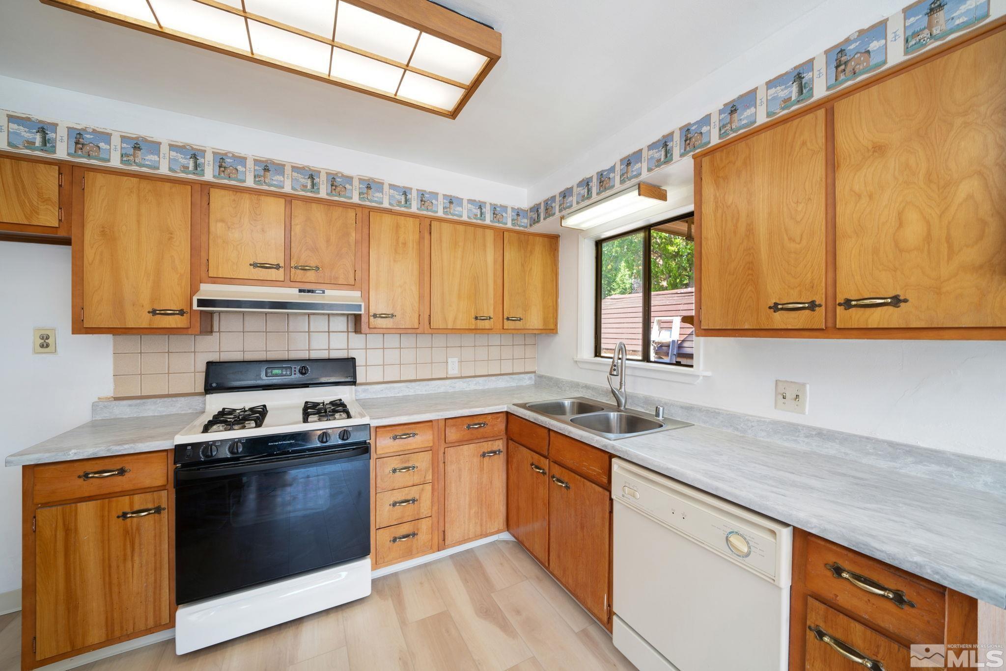 1535 Harvard Way Reno, NV 89502 - Photo 13 of 26 a kitchen with stainless steel appliances a sink a stove and a window