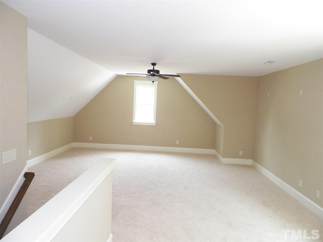 6128 Spring Branch Circle Raleigh, NC 27603 - Photo 18 of 25 an empty room with a chandelier fan and windows