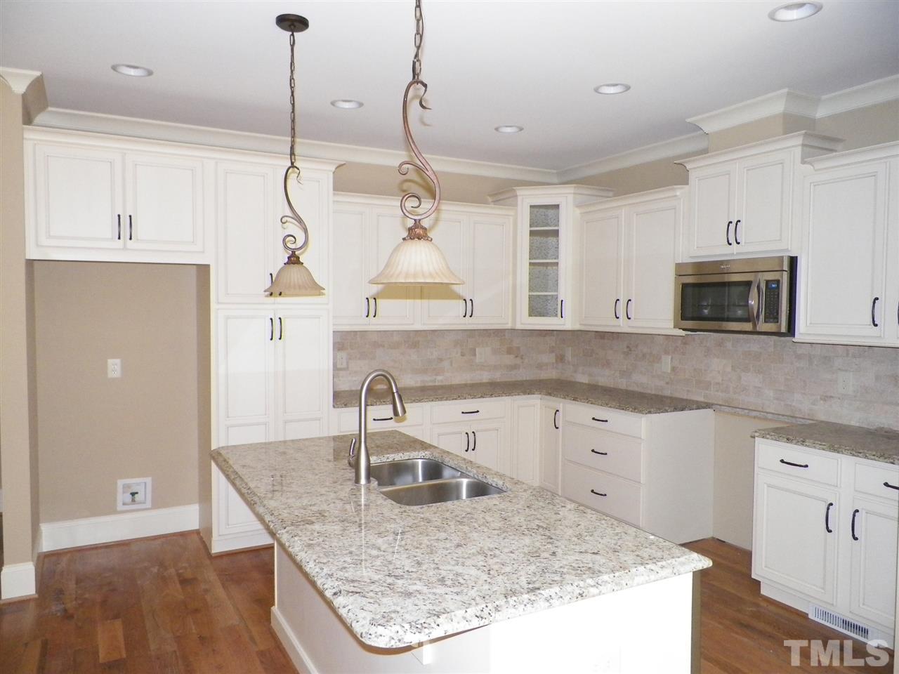 6128 Spring Branch Circle Raleigh, NC 27603 - Photo 7 of 25 a kitchen with stainless steel appliances granite countertop a sink a stove and a wooden floors